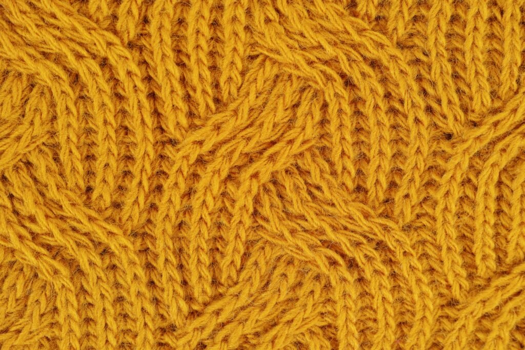 pexels-photo-1487703-1487703 Detailed close-up of a yellow knitted wool pattern, ideal for textile design.