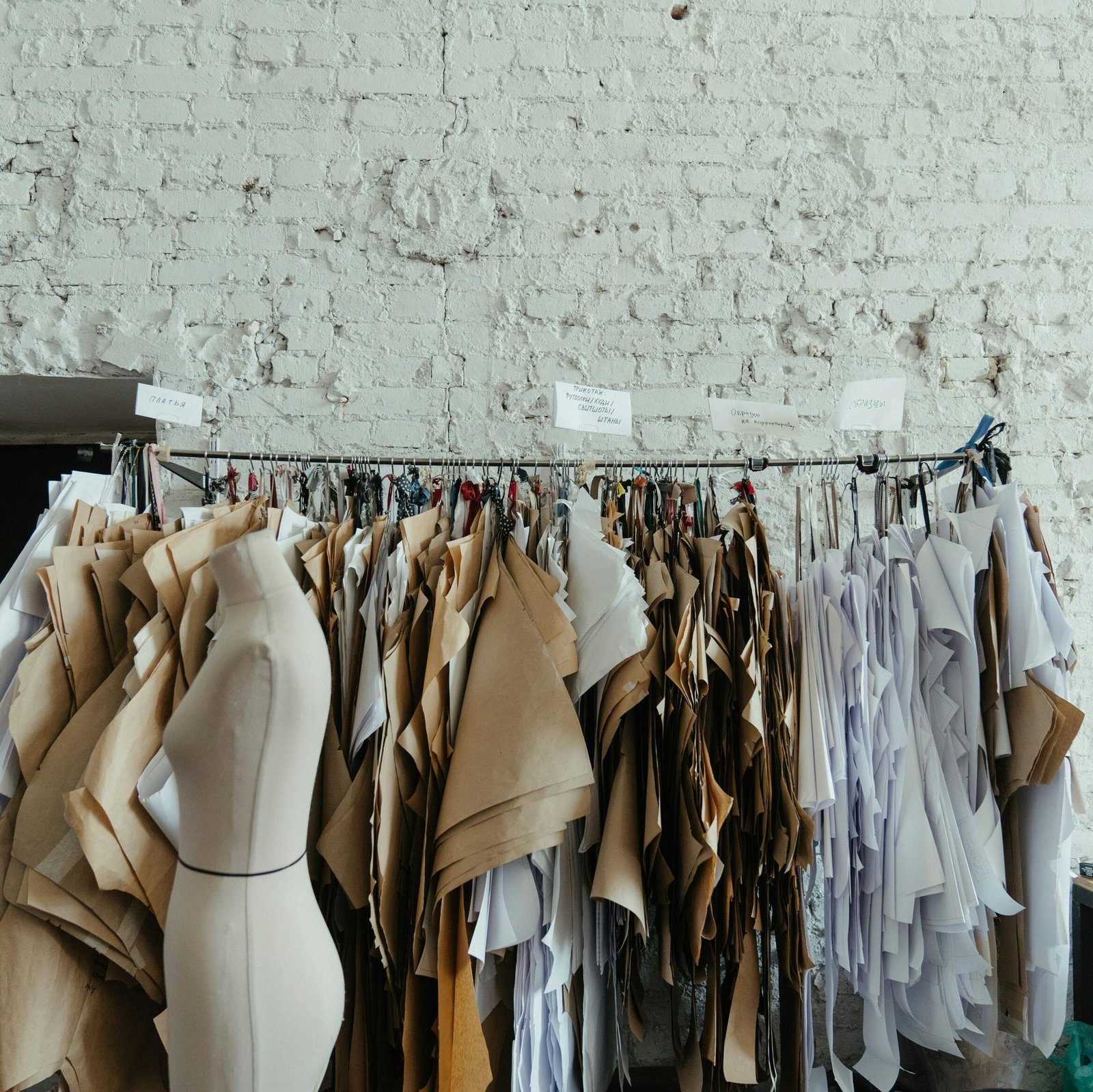 pexels-photo-4621660-4621660 Industrial fashion studio interior with various sewing patterns and mannequins against a brick wall.